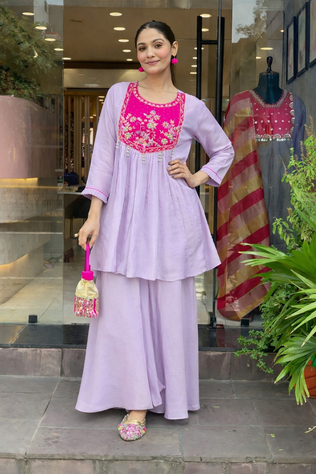 Elegant lavender kurta set with a striking magenta yoke, detailed floral embroidery, fine zari work, and pearl tassels for a rich festive look.