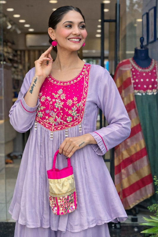 Elegant lavender kurta set with a striking magenta yoke, detailed floral embroidery, fine zari work, and pearl tassels for a rich festive look.