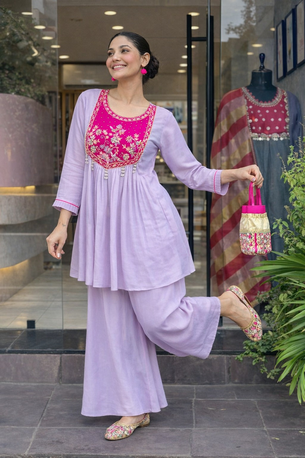 Elegant lavender kurta set with a striking magenta yoke, detailed floral embroidery, fine zari work, and pearl tassels for a rich festive look.