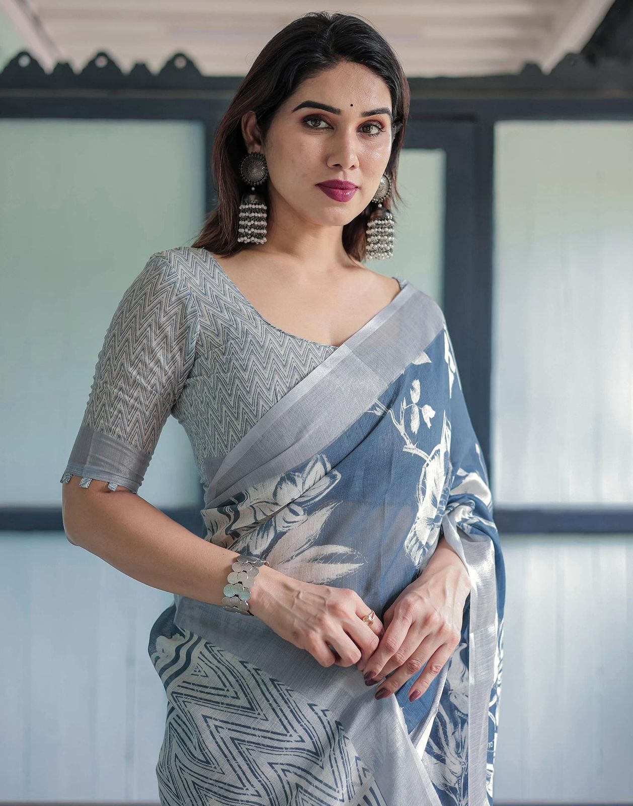 Elegant Slate Blue Mulmul Cotton Saree featuring Large Ivory Floral Block Prints, Geometric Pallu Details, and a Coordinating Textured Silver-Gray Blouse
